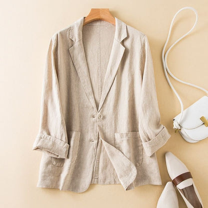 Beige blazer on a wooden hanger with a white handbag and shoes on a beige background